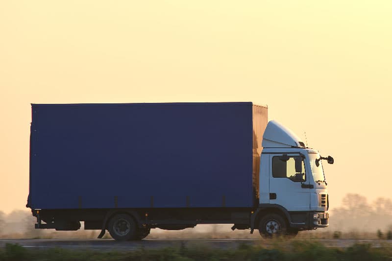 Cargo truck driving on a highway hauling goods